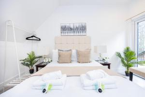 a white bedroom with a large bed with two pillows at Private Room with Private Bathroom Croydon in Croydon
