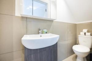 Private Room with Private Bathroom Croydon في كرويدون: حمام مع حوض أبيض ومرحاض