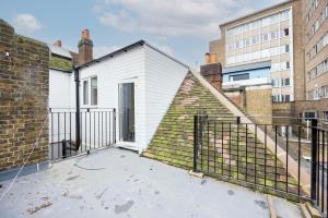 a white house with a fence on a balcony at Private Room with Private Bathroom Croydon in Croydon