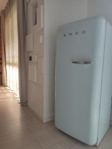 a white refrigerator in a room with a hallway at Manila House - private garage - Milan IEO Humanitas in Locate di Triulzi