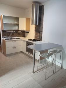 a kitchen with a table and two bar stools at Manila House - private garage - Milan IEO Humanitas in Locate di Triulzi