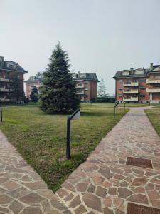a tree in the middle of a field with buildings at Manila House - private garage - Milan IEO Humanitas in Locate di Triulzi