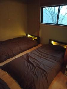 那须町小川のせせらぎを聞きながらウッドデッキでバーベキュー！｜CHILL SWING的有窗户的房间里有两张床