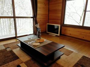 那须町小川のせせらぎを聞きながらウッドデッキでバーベキュー！｜CHILL SWING的带桌子和电视的客厅