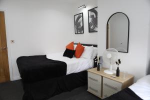 a bedroom with a bed and a mirror at Cardiff Retreat with Private Garden! Perfect for Contractors, Tourists, Relocators in Cardiff