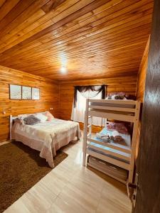 a bedroom with two beds in a wooden cabin at casa dos sonhos in Bom Jardim da Serra