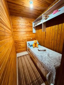 un orsacchiotto seduto su un letto in una stanza di casa dos sonhos a Bom Jardim da Serra