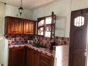 a kitchen with wooden cabinets and a counter top at CASA HOSPEDAJE PRANA in Jardin