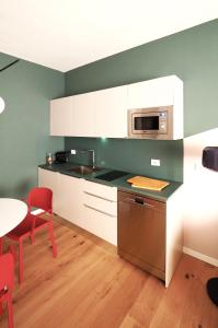 uma cozinha com armários brancos, uma mesa e um micro-ondas em Luxury Loft Marghera em Milão