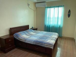 ein Schlafzimmer mit einem Bett, einer Kommode und einem Fenster in der Unterkunft Adventurer's Vacation Home in Alaminos