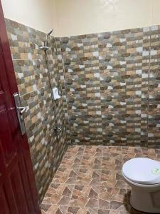 ein Bad mit einem WC und einer Dusche in der Unterkunft Adventurer's Vacation Home in Alaminos