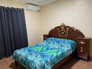 Schlafzimmer mit einem Bett mit blauer Decke in der Unterkunft Adventurer's Vacation Home in Alaminos