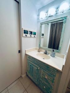 ein Bad mit einem Waschbecken und einem Spiegel in der Unterkunft Aloha Surf Hotel -2 blocks from Waikiki Beach in Honolulu