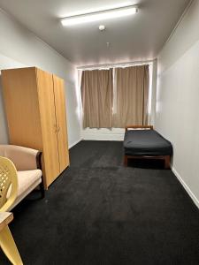 um quarto com um sofá, uma cama e uma janela em Hamilton City Inn em Hamilton