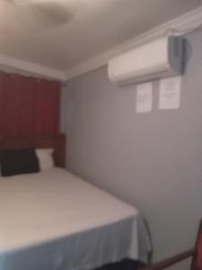 a small bedroom with a bed and a air conditioner at Errol and Nancys place in Stapleton Gardens