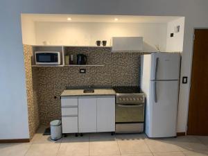 uma cozinha com electrodomésticos brancos e um frigorífico branco em Monoambiente nuevo y luminoso en Flores em Buenos Aires