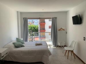 um quarto com uma cama, uma cadeira e uma janela em Monoambiente nuevo y luminoso en Flores em Buenos Aires
