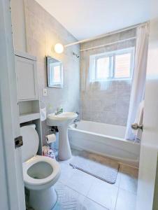 W łazience znajduje się toaleta, wanna i umywalka. w obiekcie Portsmouth Village Retreat w mieście Kingston