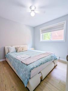 Cama en habitación blanca con ventana en Portsmouth Village Retreat, en Kingston