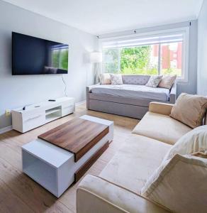 a living room with a couch and a tv at Portsmouth Village Retreat in Kingston