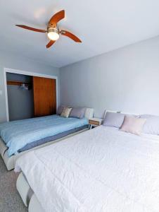 sypialnia z 2 łóżkami i wentylatorem sufitowym w obiekcie Portsmouth Village Retreat w mieście Kingston