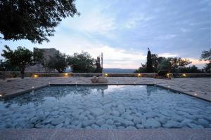 a pool of water with white rocks in it at Citta dei Nicliani in Koíta