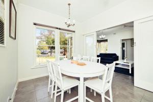 a dining room with a white table and white chairs at 3 BR House Near Airport in West Richmond