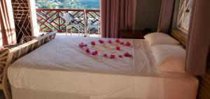 a bed with pink roses and candles on it at Nia's Hillside Loft - Exquisite Views in Gros Islet