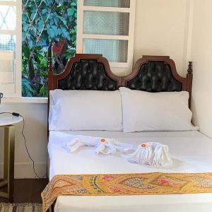 a bedroom with a bed with two towels on it at Courtyard Hotel in Manila