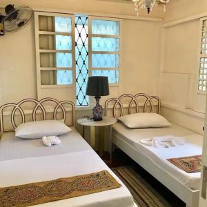 two beds in a room with a window at Courtyard Hotel in Manila