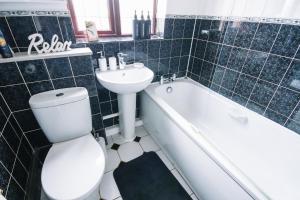 a bathroom with a toilet and a sink and a bath tub at Convenient Stay for ALL OCCASIONS in Cheshunt