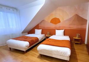 dwa łóżka w pokoju z obrazem na ścianie w obiekcie L'évasion appart, proche disney, 8 pers. w mieście Collégien