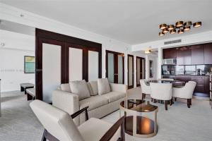 ein Wohnzimmer mit einem Sofa, Stühlen und einem Tisch in der Unterkunft Fontainebleau Miami Beach in Miami Beach