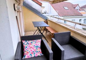 balkon z 2 krzesłami i stołem z laptopem w obiekcie L'évasion appart, proche disney, 8 pers. w mieście Collégien