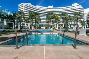 einem Pool vor einem großen Gebäude in der Unterkunft Fontainebleau Miami Beach in Miami Beach