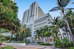 ein großes weißes Gebäude mit Palmen davor in der Unterkunft Fontainebleau Miami Beach in Miami Beach