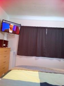 a bedroom with a bed and a tv on the wall at Double guest room in Sedgley