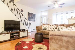 a living room with a couch and a flat screen tv at Spacious Passyunk Square 3BR House in Philadelphia