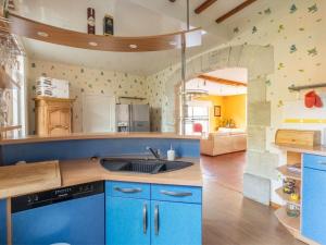 una grande cucina con armadi blu e lavandino di Grand Gîte à Louvemont : 8 Chambres, Piscine Chauffée, Proche Lac et Activités outdoor - FR-1-611-69 a Louvemont