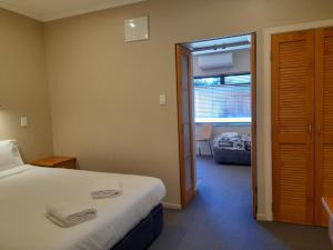 a hotel room with a bed and a window at Tongariro Junction Accommodation in Turangi