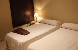 Habitación de hotel con 2 camas y mesa con lámpara en Alquileres Temporarios Darío en Maipú