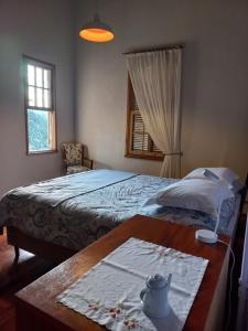 een slaapkamer met een bed en een tafel met een theepot erop bij Caliluma in Gonçalves