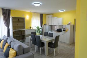 a living room with a table and a kitchen at SD PRENOĆIŠTE in Vranje