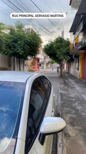 una macchina bianca parcheggiata sul lato di una strada di apartamento no centro a Canindé