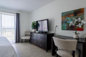 a bedroom with a desk with a television on a dresser at Crawford View in Kelowna