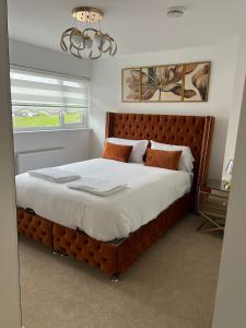 a bedroom with a large bed with a wooden headboard at Elegant House in Barnstaple