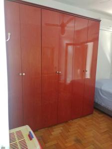 a large wooden cabinet in a room with a bed at Próximo ao Consulado - Quarto Inteiro in Porto Alegre