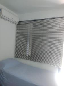 a bedroom with a bed and a window with blinds at Próximo ao Consulado - Quarto Inteiro in Porto Alegre
