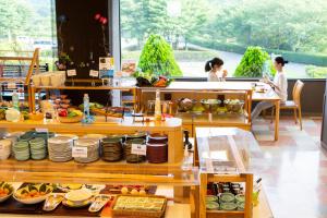 a buffet in a restaurant with people sitting at tables at Kyukamura Minami-Aso in Takamori