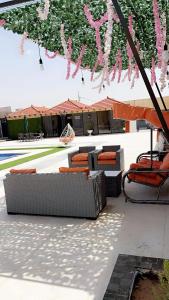 un patio con sofás y sillas bajo una sombrilla en شاليه نايا, en Kerak